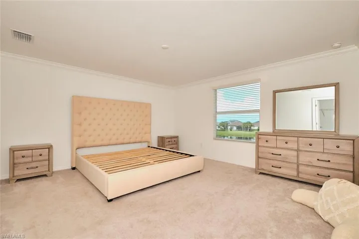 Bedroom with crown molding and carpet floors