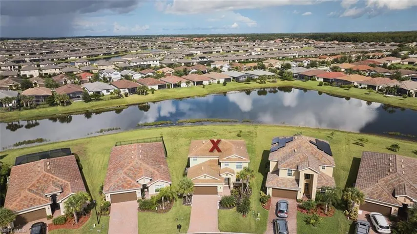 Aerial view of property and surrounding area with nearby suburban area and a large body of water
