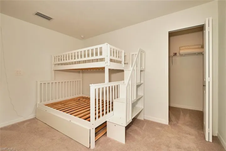 Unfurnished bedroom featuring light colored carpet and a closet