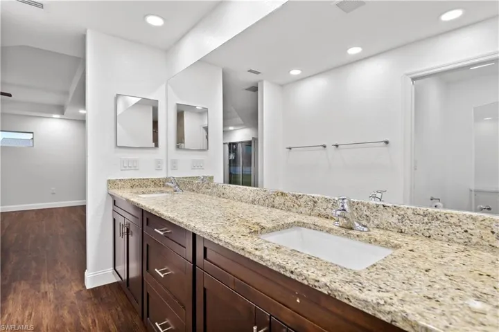 Primary Bathroom duel sinks, solid surface countertops and wood cabinets.