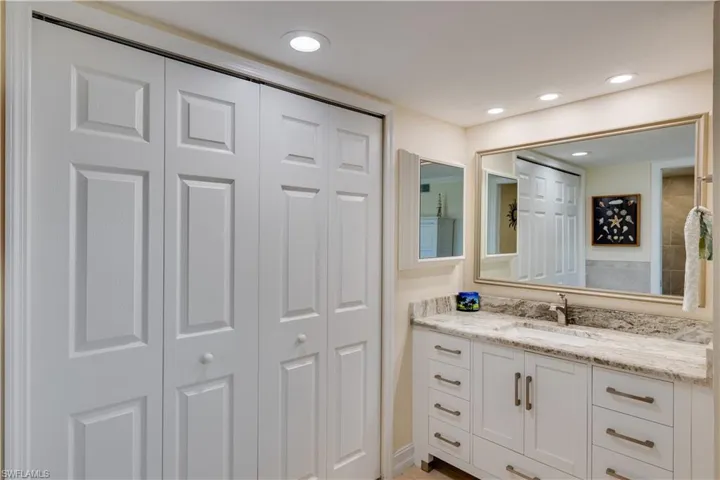 Primary Bathroom with a closet, vanity, and recessed lighting