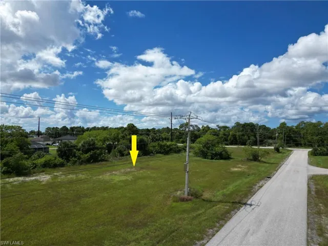View of property's community featuring a yard and view of wooded area