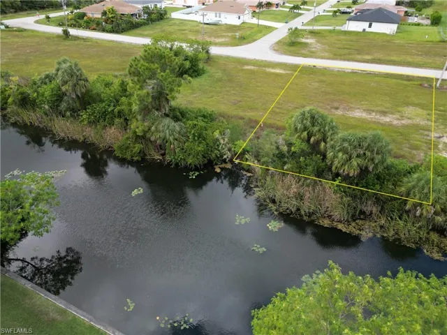 Aerial view of property and surrounding area featuring property boundaries highlighted and a nearby body of water