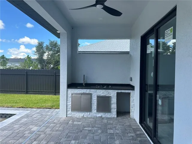 View of patio / terrace featuring an outdoor kitchen, sink, and ceiling fan