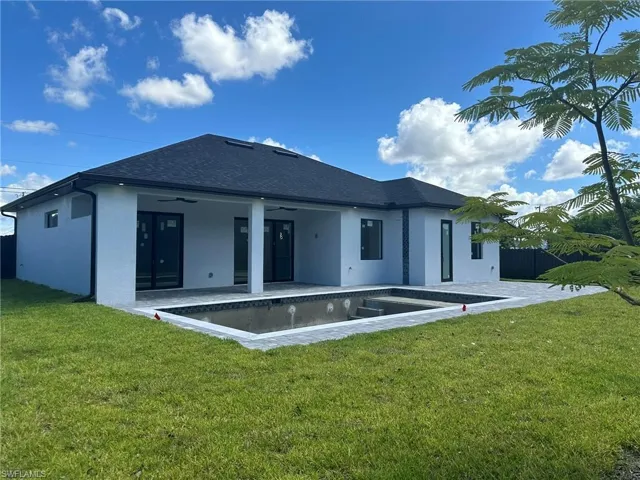 Back of house with a yard, ceiling fan, and a patio area