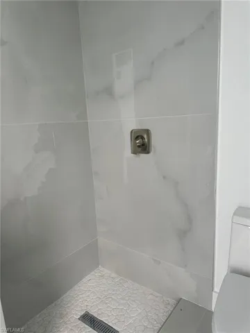 Bathroom with toilet, tile patterned floors, and walk in shower