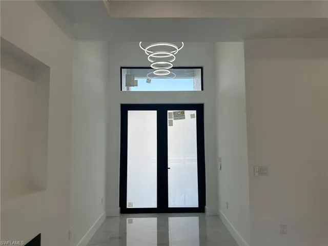 Foyer with an inviting chandelier and tile patterned floors
