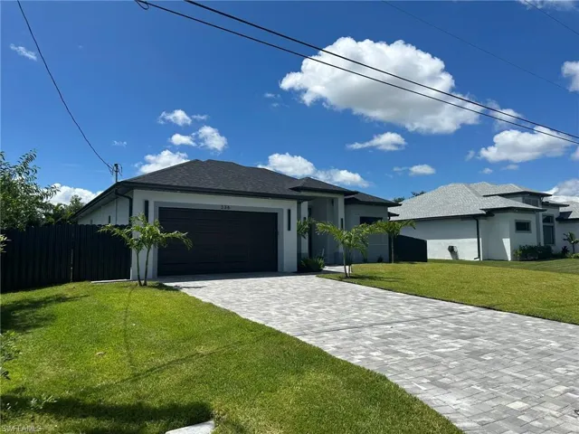 View of front of house featuring a garage and a front yard