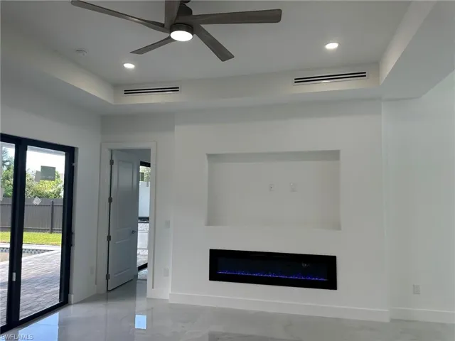 Unfurnished living room with light tile patterned floors and ceiling fan
