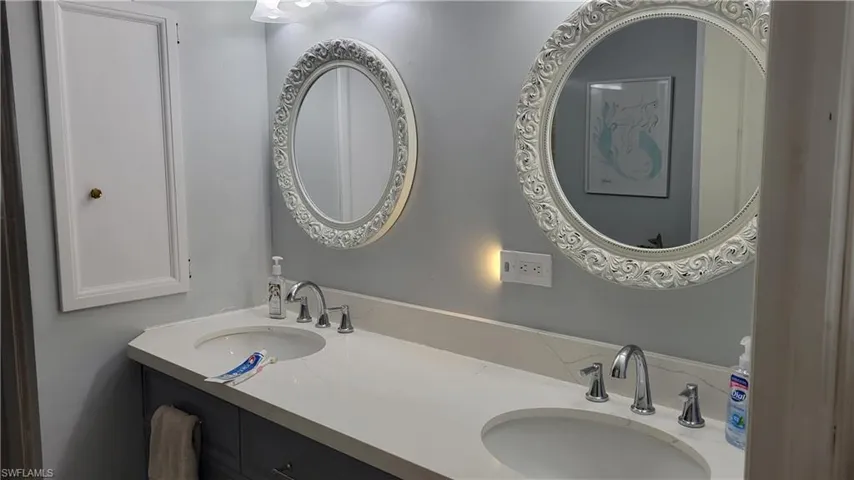 2nd bathroom featuring double sinks and walk in shower.