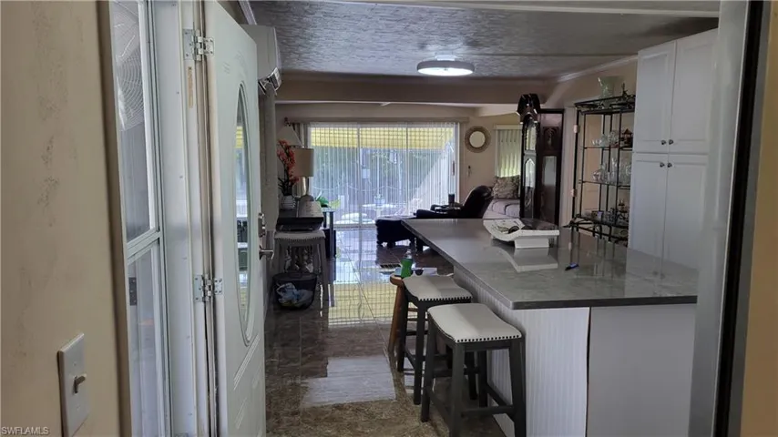 View of partial kitchen from hall with beautiful island