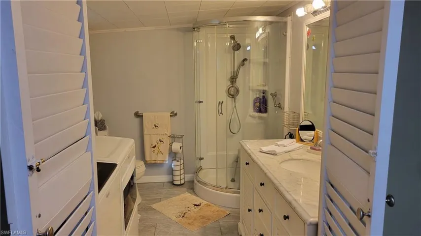 Ensuite equipped with washer, dryer, vanity and corner shower.