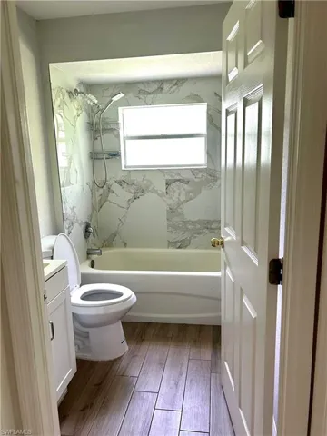 Full bathroom featuring shower / bathtub combination, vanity, and light wood finished floors