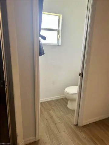 Bathroom with light wood finished floors and a textured wall