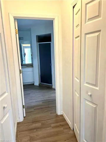 Corridor featuring light wood-style floors and baseboards