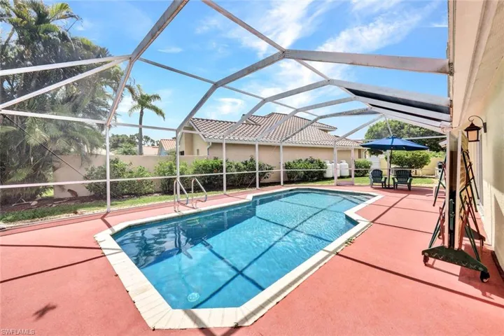 View of swimming pool featuring a lanai and a patio area, there is a covered lanai area the width of the home on the lake. The pool is gas heated and was just resurfaced in 2023.