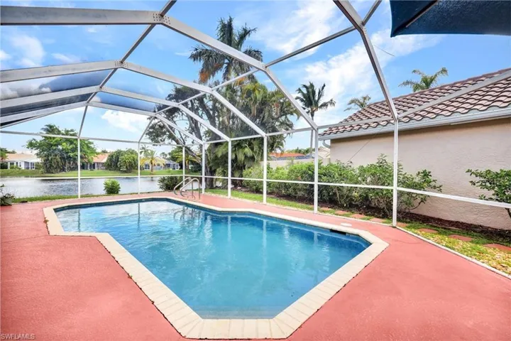 View of pool with glass enclosure and a patio area