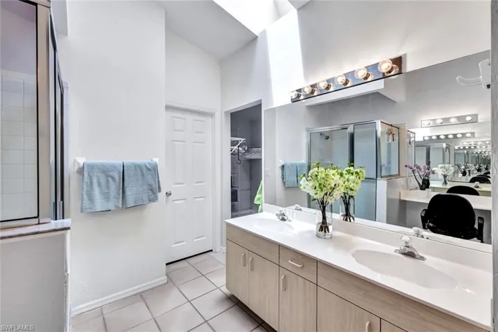 Bathroom featuring tile flooring and double vanity, super sized walk in closet just around the corner.