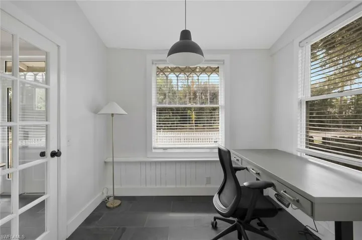 Home office with a wainscoted wall and dark tile patterned flooring