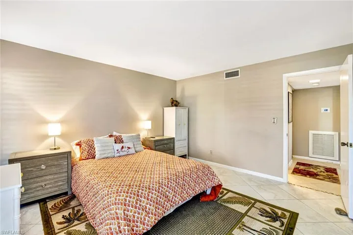 Bedroom with light tile patterned flooring and baseboards