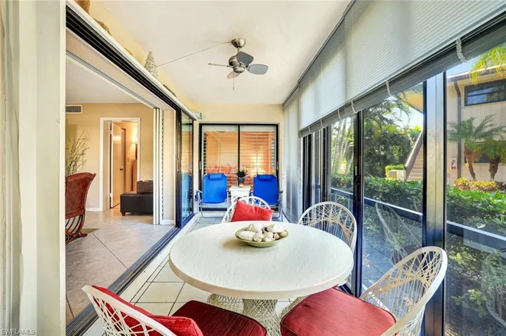 Sunroom / solarium with ceiling fan, tile patterned flooring, and outdoor dining space