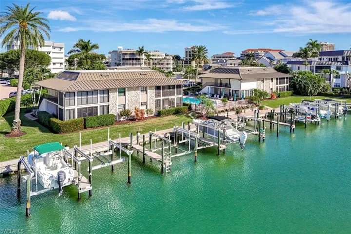 Dock featuring boat lift, a water view, and a yard