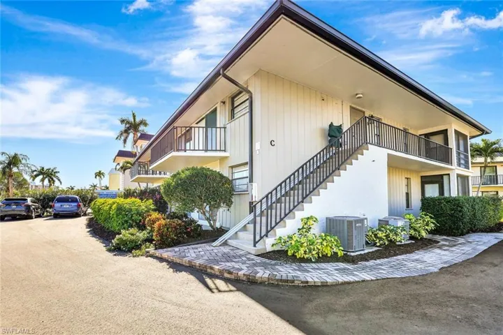 View of property exterior with stairway and a balcony