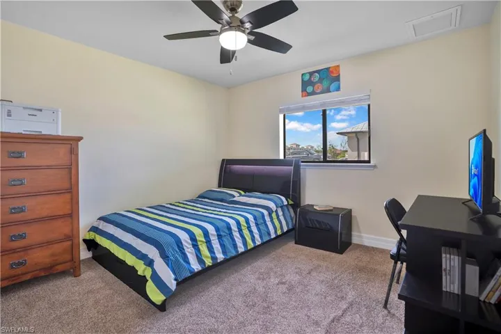 Bedroom featuring carpet, ceiling fan, and an office area