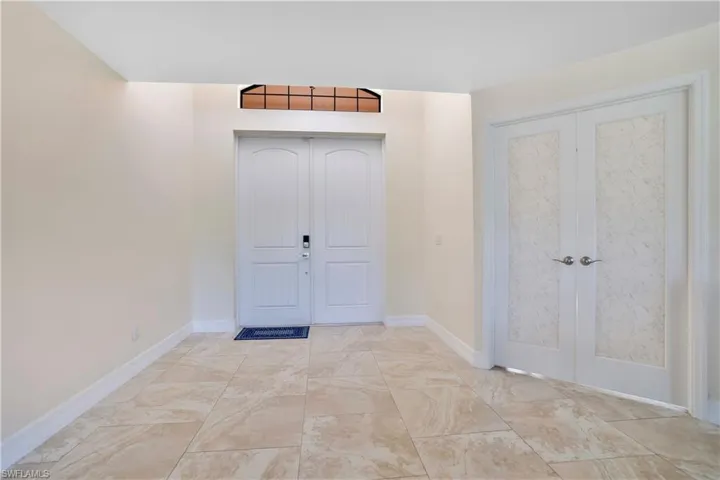 Foyer featuring french doors and baseboards