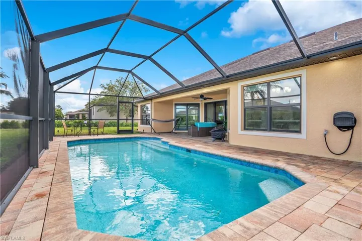 Outdoor pool with a sunroom, a patio, and a lanai