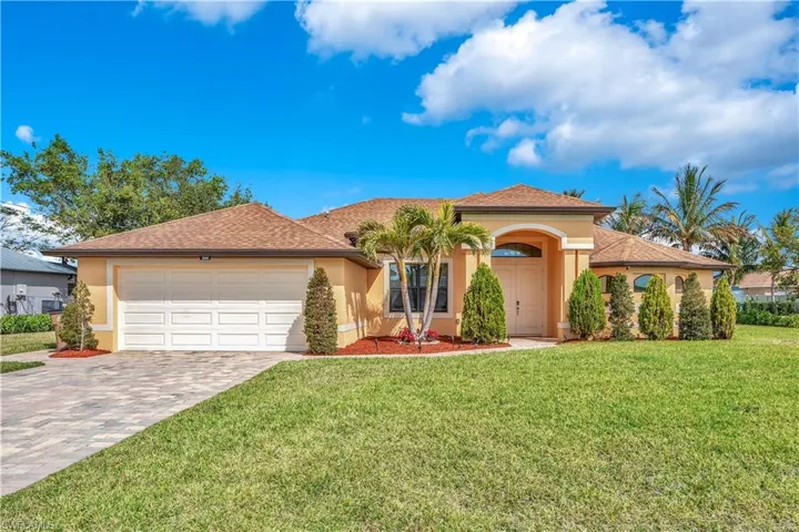 Mediterranean / spanish home featuring stucco siding, driveway, a garage, and a front yard