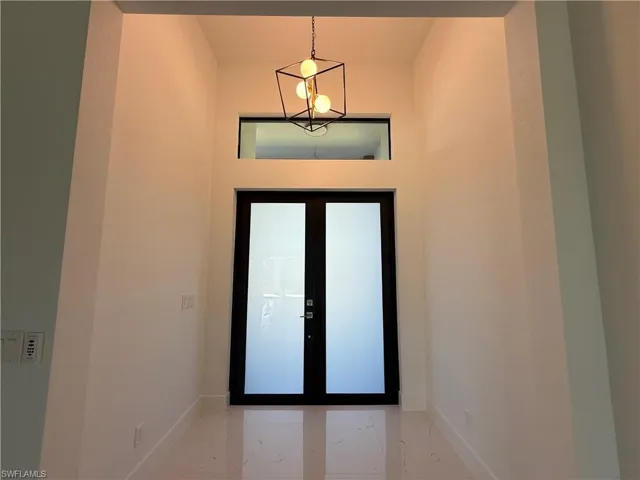 Entrance foyer featuring baseboards and marble finish flooring