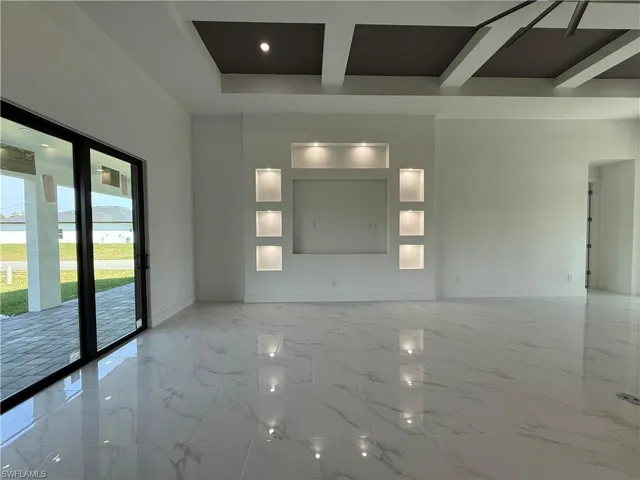 Unfurnished room featuring coffered ceiling, marble finish floor, baseboards, and beam ceiling