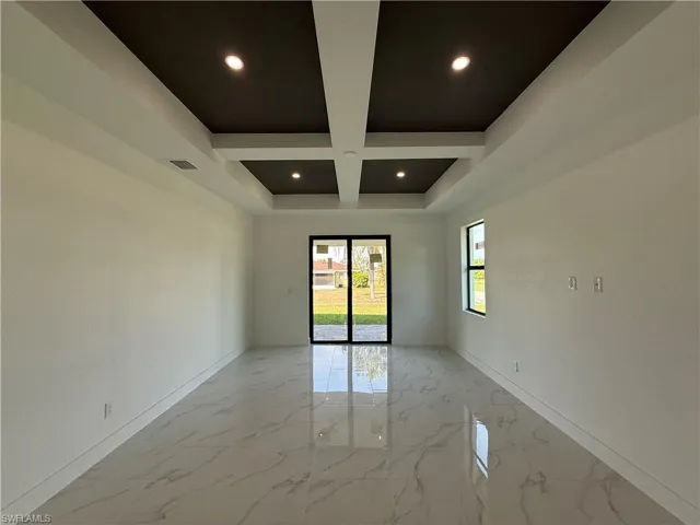 Empty room with recessed lighting, marble finish floor, baseboards, and coffered ceiling