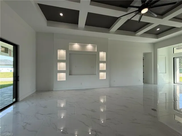 Kitchen with visible vents, a large island, a sink, under cabinet range hood, and stainless steel appliances