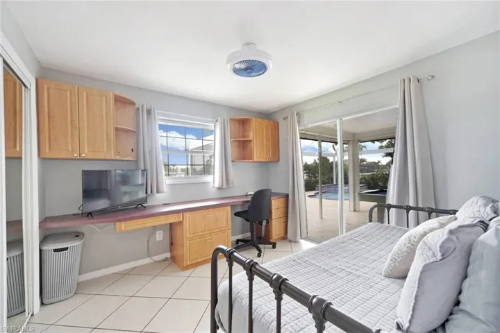Bedroom 4, featuring access to exterior, built in desk, and day bed that expands with great view of the pool with slidng glass door.