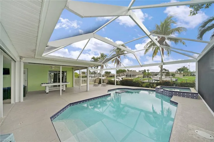View of swimming pool featuring a table for drinks, heated spa for relaxing after day of boating or pickle ball.
