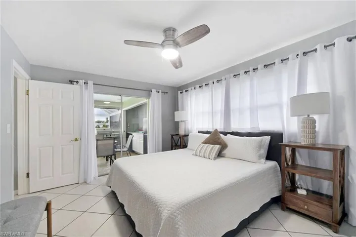 Generous sized master suite with continuous tile floor installed on the diagonal through out, and sliding glass door to view the pool and canal.