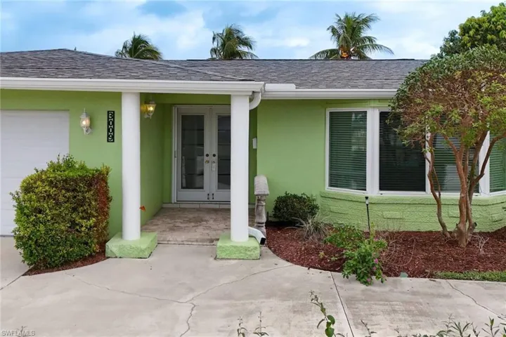 View of exterior entry featuring a garage and french doors