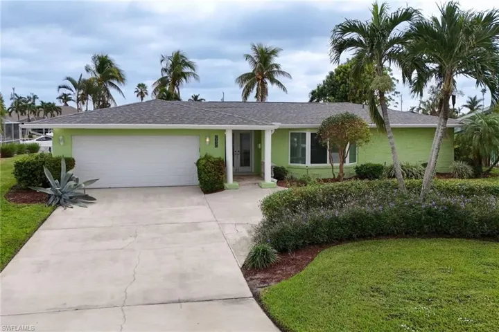Ranch-style house featuring a garage and a front lawn