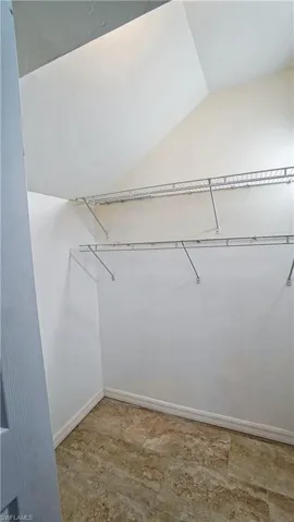 Spacious closet featuring vaulted ceiling