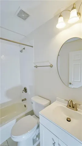Full bath featuring shower / tub combination, visible vents, toilet, and vanity