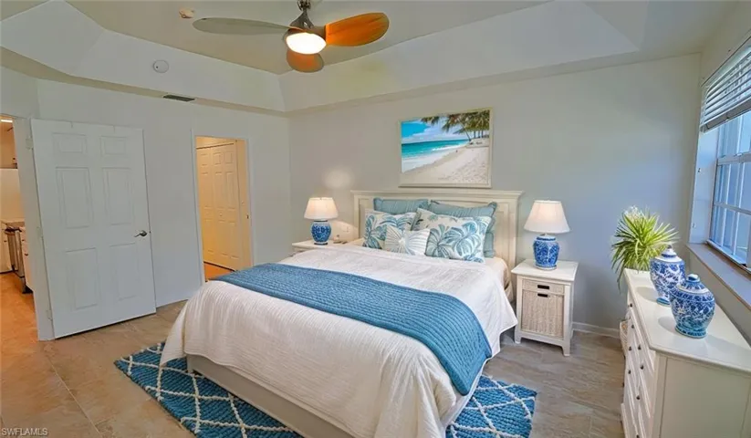 Bedroom featuring visible vents, a tray ceiling, baseboards, and ceiling fan. (virtual staged photos)