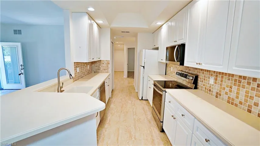 Kitchen with a sink, freestanding (virtual staged photos) refrigerator, visible vents, recessed lighting, and stainless steel electric range oven