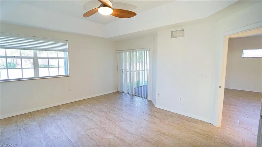Unfurnished room with baseboards, visible vents, ceiling fan, and a healthy amount of sunlight