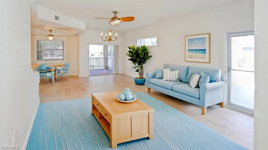 Living area featuring ceiling fan with notable chandelier, baseboards, and visible vents. (virtual staged photos)