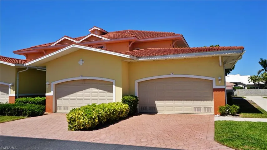 Mediterranean / spanish-style house featuring stucco siding, an attached two car garage, a tiled roof, and decorative brick paver driveway