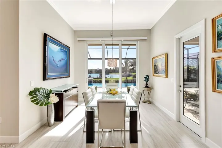 Dining room with light hardwood / wood-style floors, a water view, and crown molding