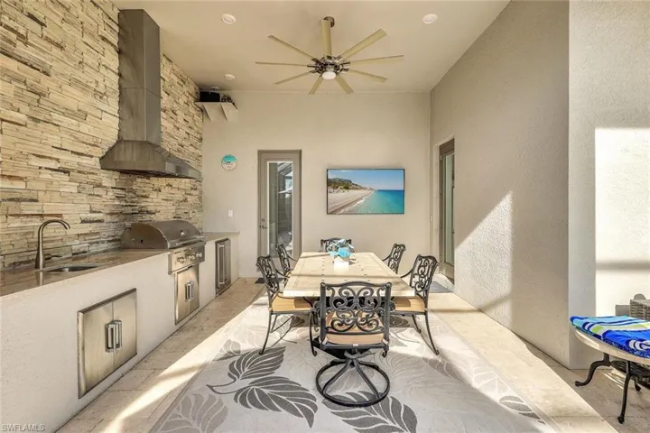 View of patio with grilling area, ceiling fan, sink, and exterior kitchen