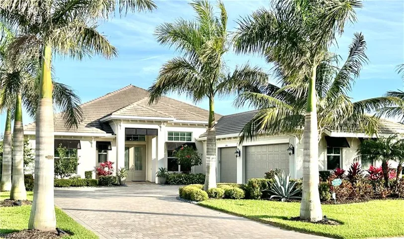 View of front of home featuring a tile roof, decorative driveway, an attached garage, and stucco siding